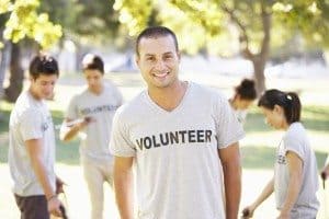 Volunteer Group Clearing Litter In Park Wearing A Vounteer T Shirt Smiling