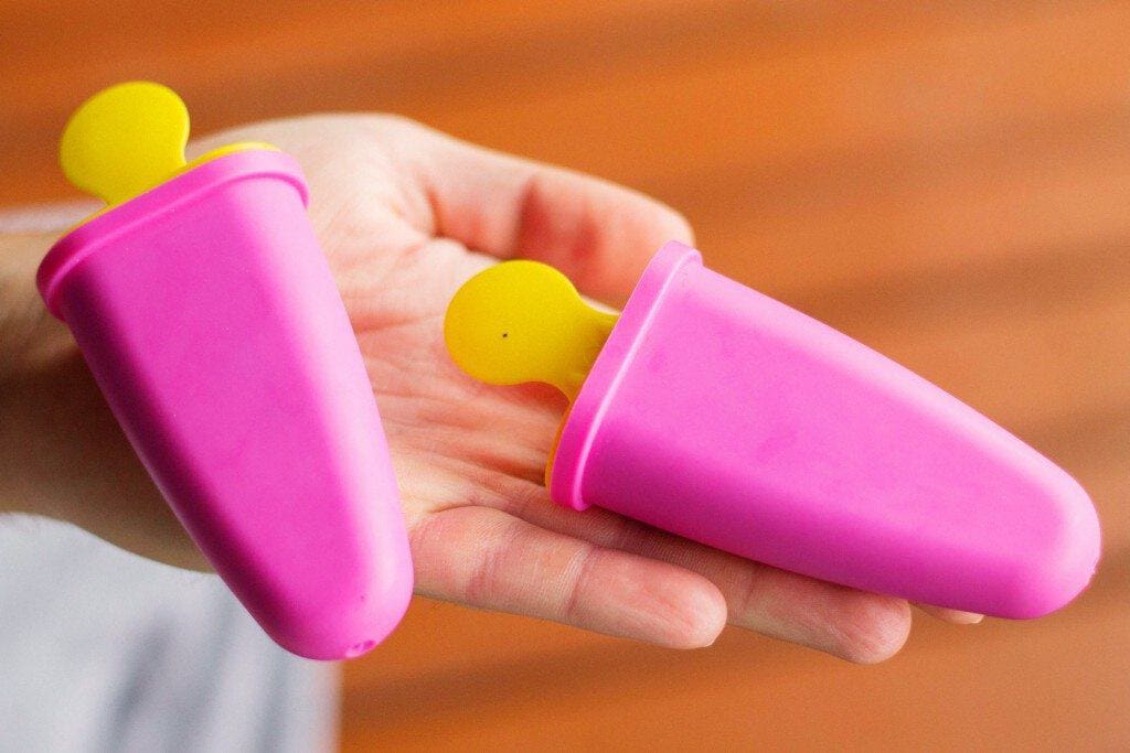 Two molds with homemade ice creams in hand.